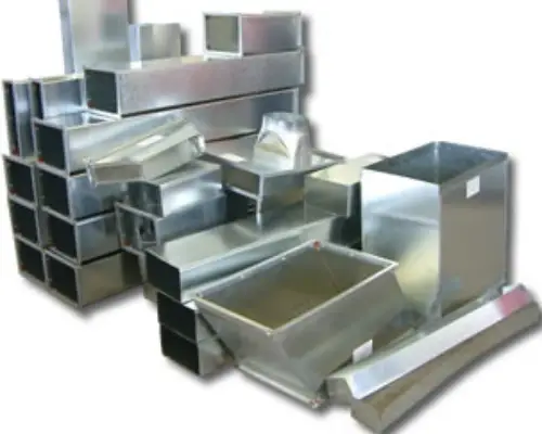 A collection of various metal ductwork pieces, including rectangular and square shapes, arranged in a chaotic pile.
